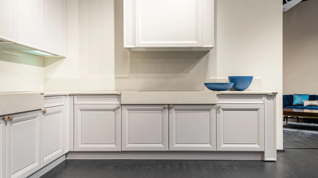 Trendy interior design of contemporary white kitchen units and cabinets in spacious light showroom