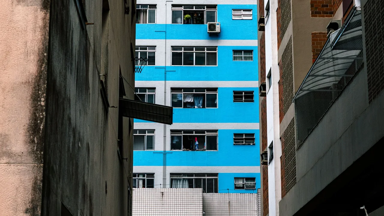Colorful urban scene with a bright blue building facade surrounded by contrasting structures.