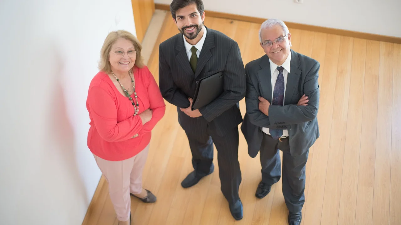 High angle view of a diverse team including a realtor with clients in a modern office.