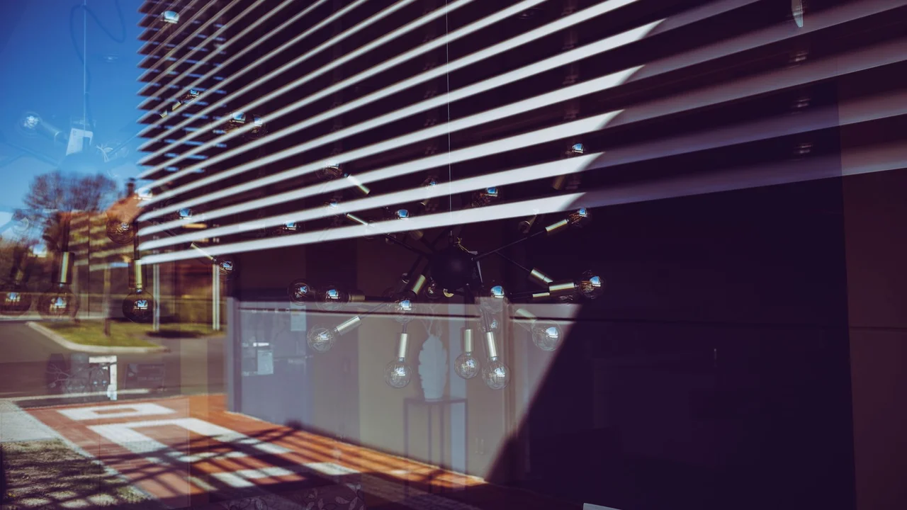 Reflected urban scene through modern window blinds with abstract architecture elements.