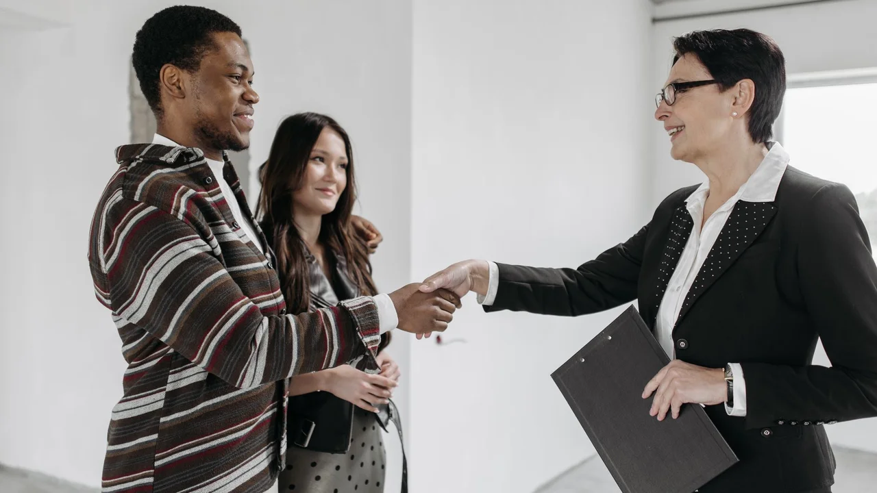 Business professionals shake hands in a modern office, symbolizing a successful deal.