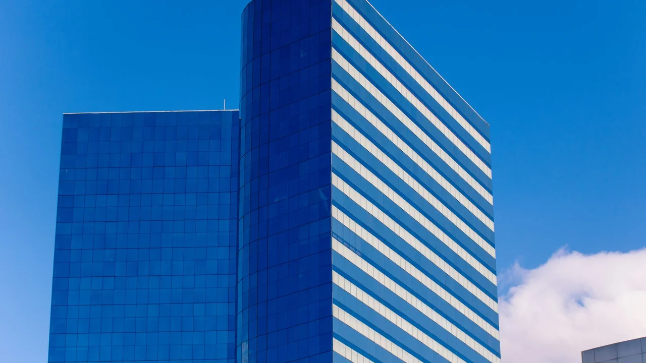 Contemporary glass skyscraper against a blue sky in São Paulo, Brazil.
